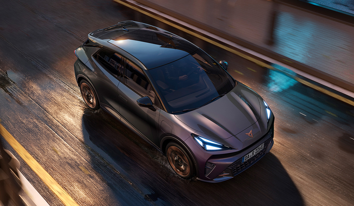 CUPRA Raval in Fahrt, von oben fotografiert auf nasser Fahrbahn - Panoramadach und dynamische Silhouette des Elektro-Crossovers gut erkennbar.